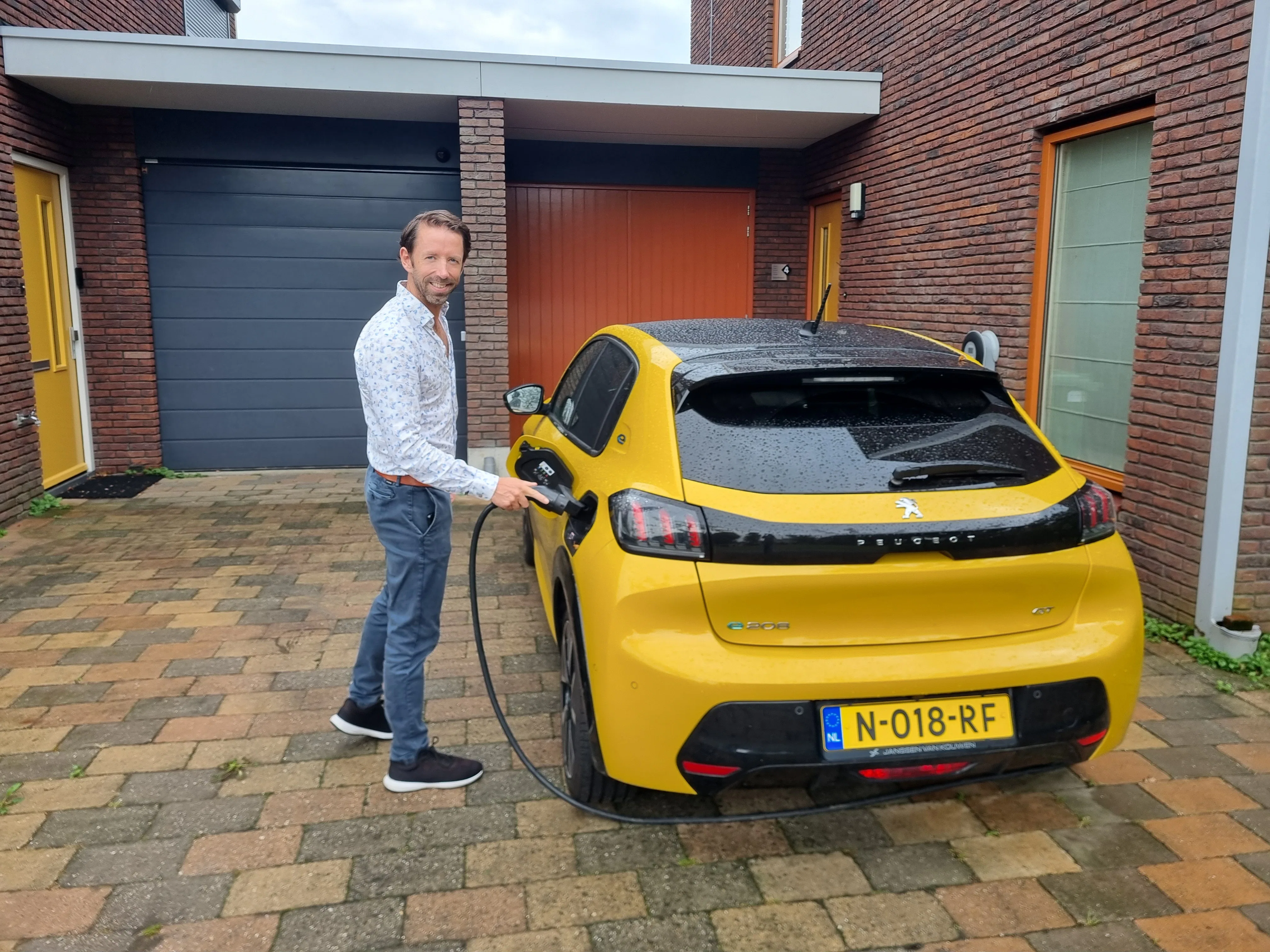 Sam van Gentevoort, mede-oprichter van Voltbee, bij een elektrische auto.